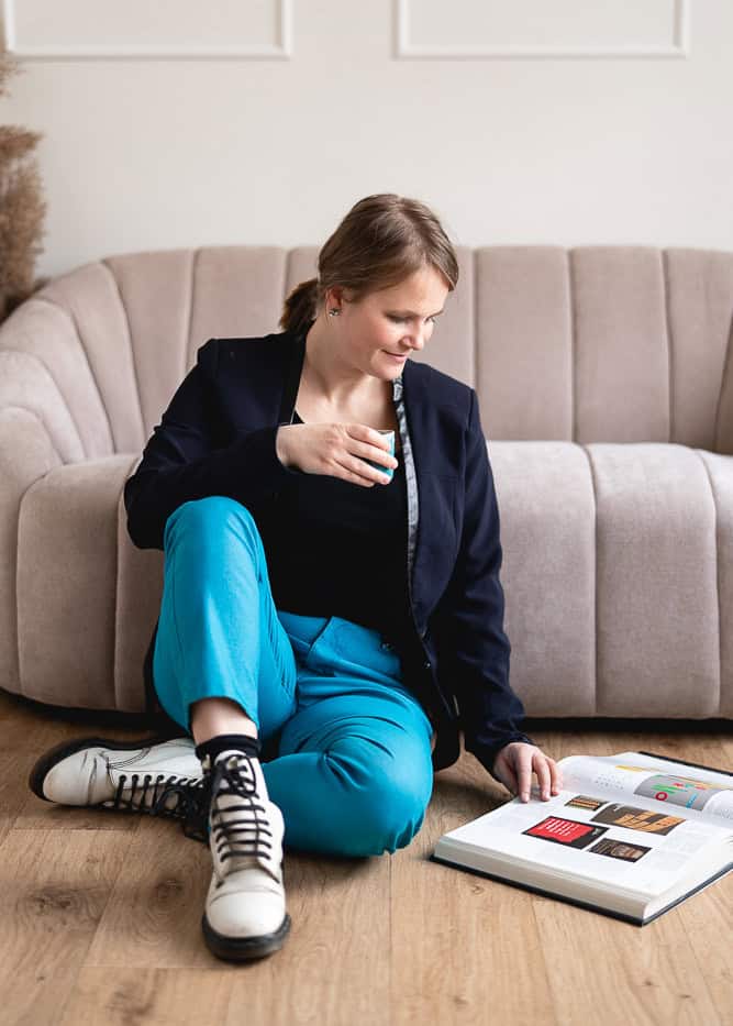 Barbora sitting on the floor, reading a book on typography